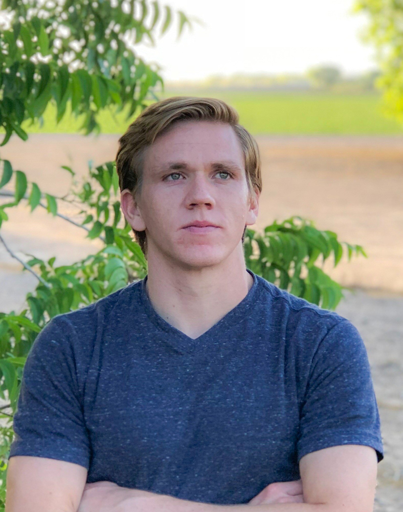 adam moore blue shirt in field with trees